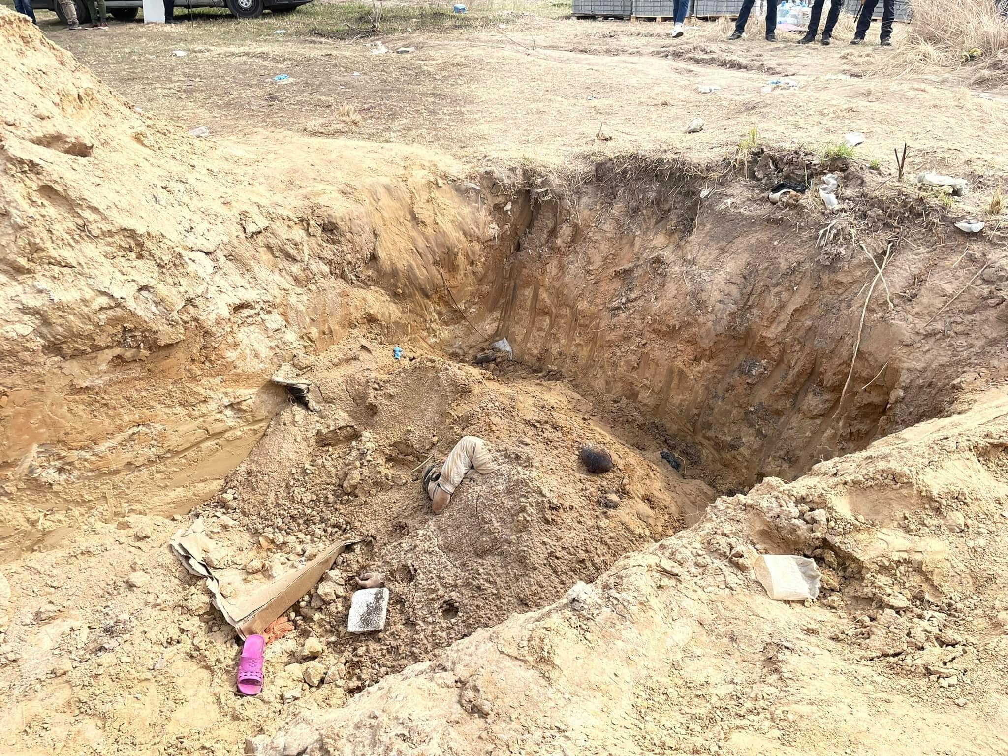 Масове вбивство мирних жителів у Бучі: криміналісти почали ексгумацію тіл з братської могили (ФОТО) - фото 2