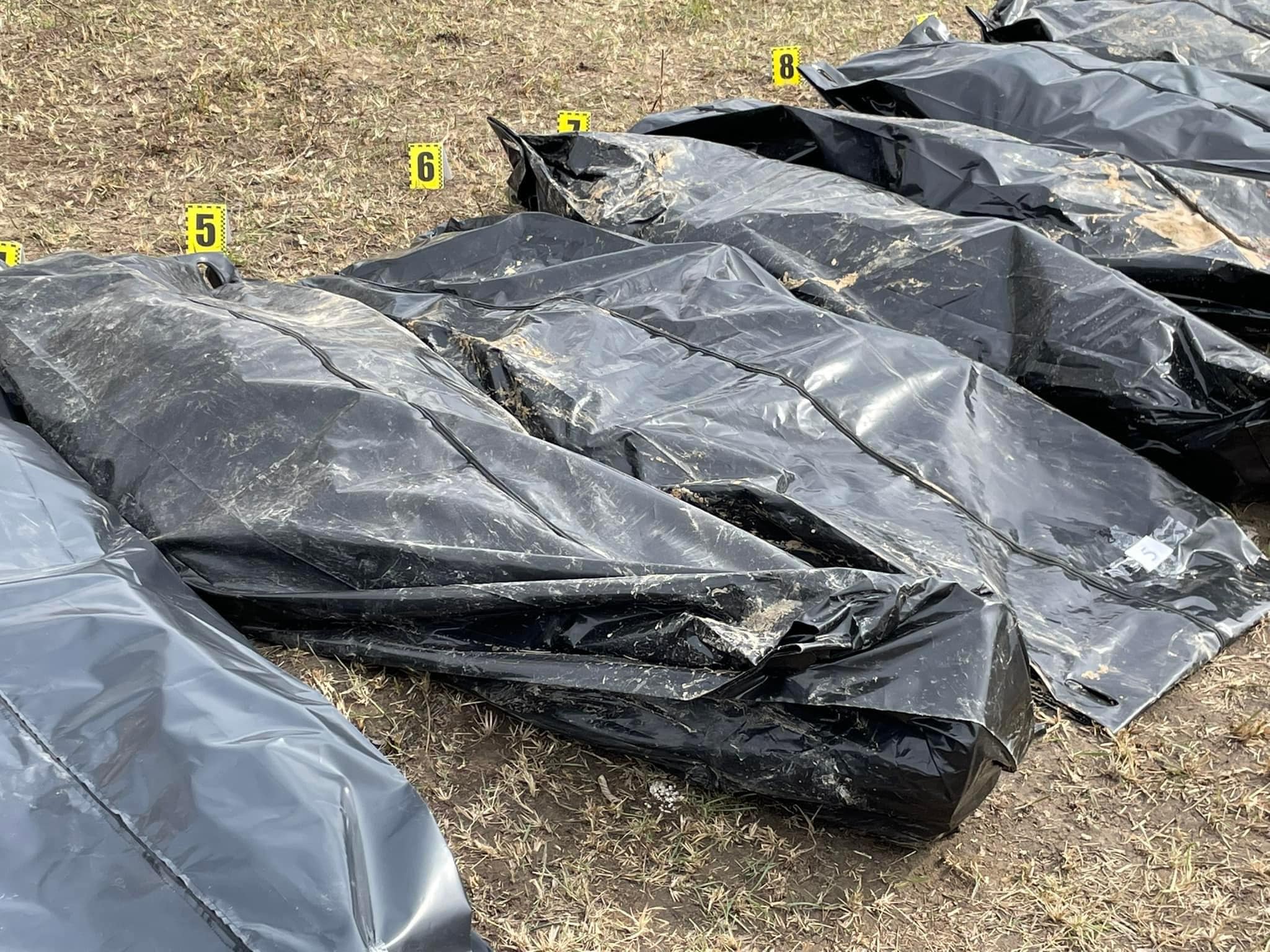 Масове вбивство мирних жителів у Бучі: криміналісти почали ексгумацію тіл з братської могили (ФОТО) - фото 4